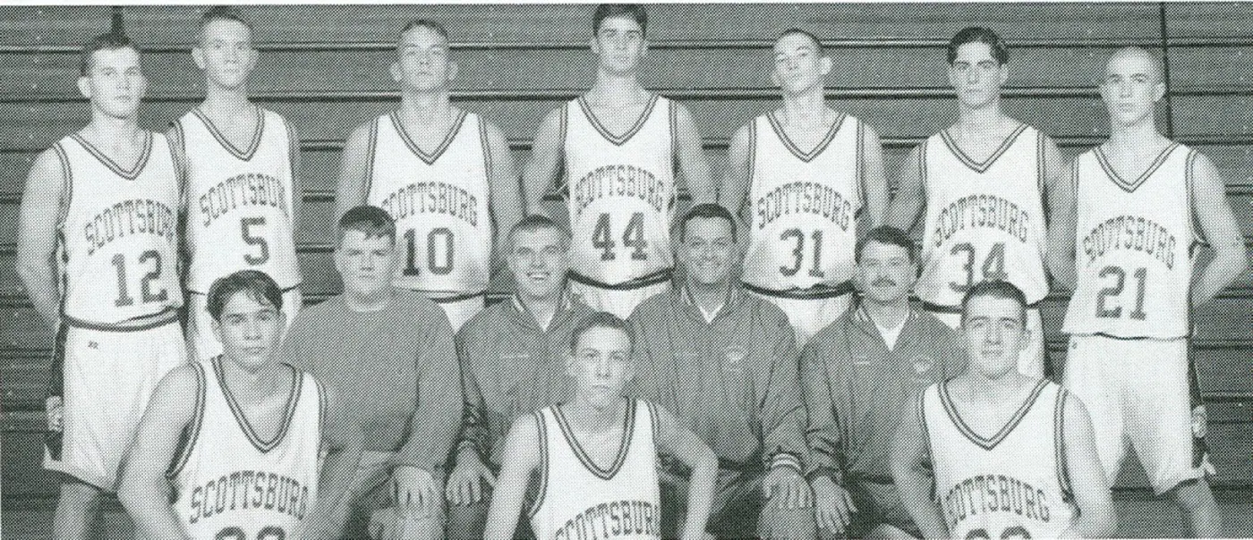 The 1995–96 Scottsburg Warriors in white uniforms with their coaches, in the bleachers