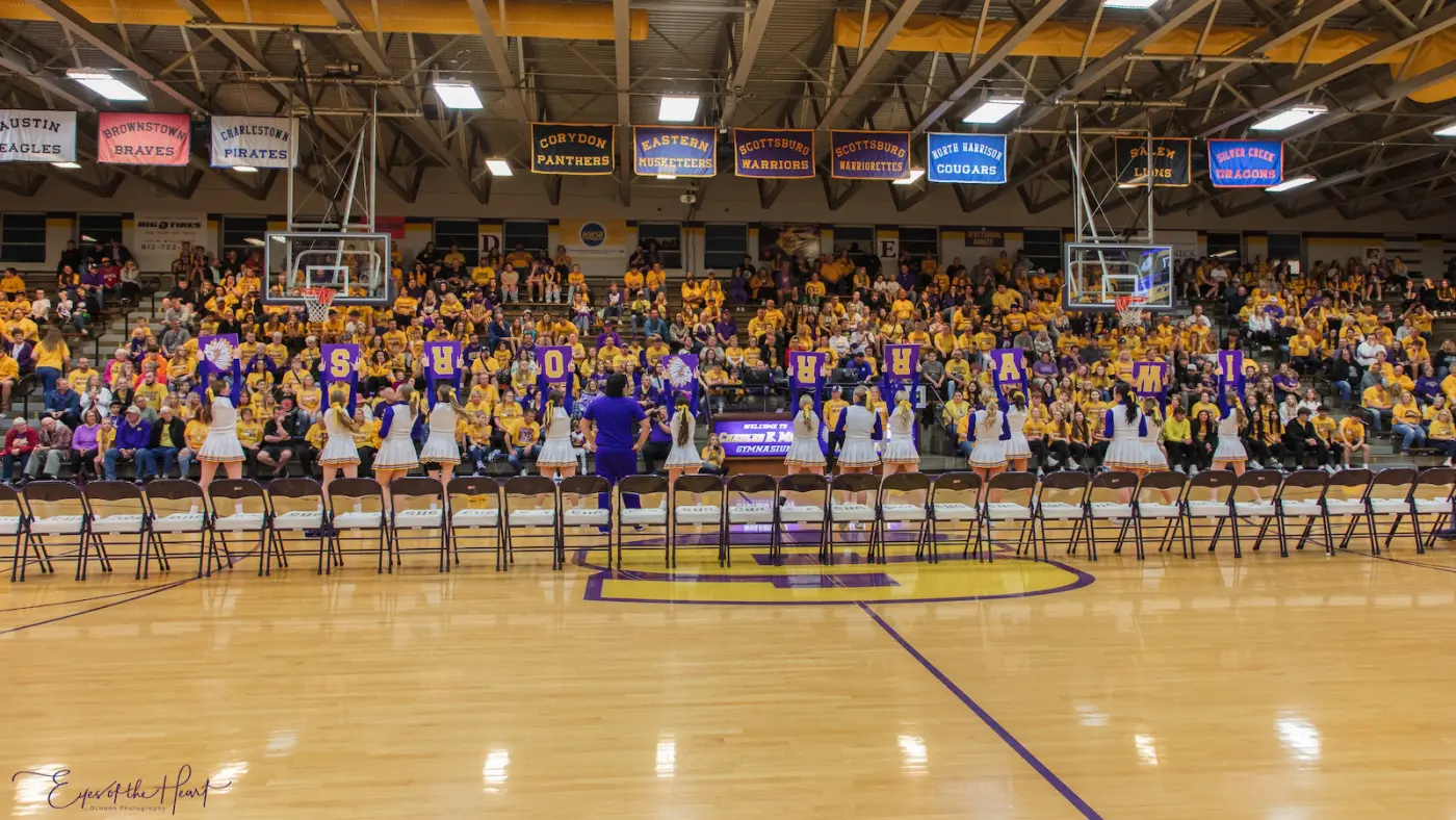 A full house in gold at the Meyer Gym, banners and pennants overhead, the floor in front