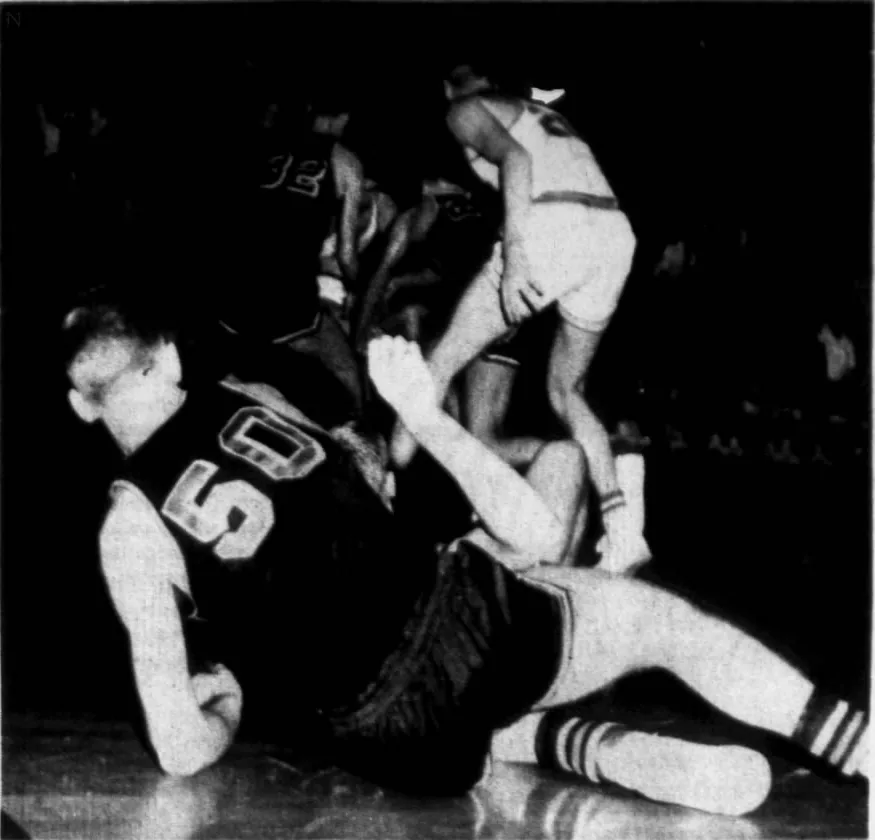 Newspaper photo: a Scottsburg player in a dark No. 50 jersey sprawled on the floor, others chasing the ball behind him