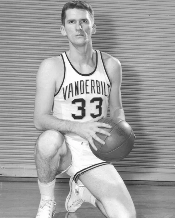Hub Hougland kneeling with a basketball in Vanderbilt's white No. 33