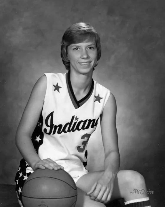 Pam Jones in her Indiana All-Stars No. 3 uniform, kneeling with a basketball