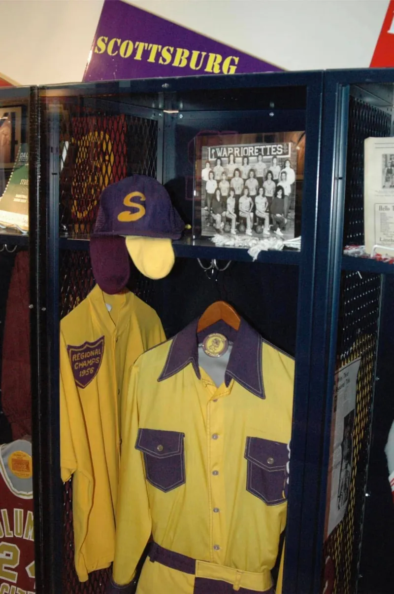A Scottsburg locker at the Indiana Basketball Hall of Fame: a purple S cap, gold and purple shirts and a Warriorettes team photo