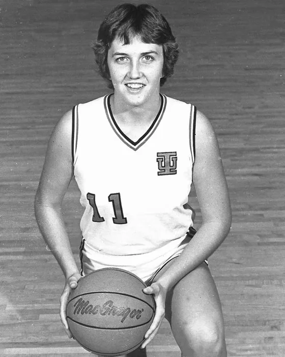 Melinda Sparkman in Indiana's white No. 11 jersey, kneeling on the floor with a basketball